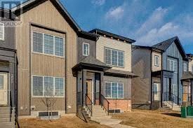 Chestermere apartment for rent - A row of modern houses with different facades and front yards.