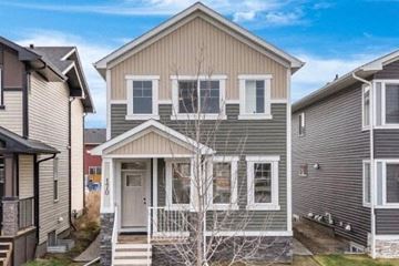 Chestermere apartment for rent - A house with a grey front and a white door is surrounded by other houses.