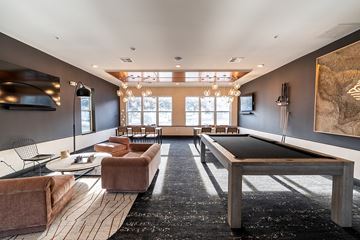 Columbus apartment for rent - A modern living room with a pool table and a large painting on the wall.