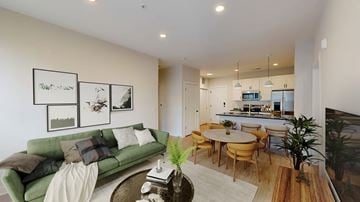 Columbus apartment for rent - A living room with a grey couch and a television on the wall.