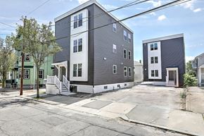 Providence apartment for rent - A row of modern townhouses with a clear blue sky above.