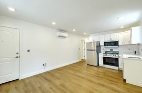 Providence apartment for rent - A kitchen with white cabinets and a wooden floor.