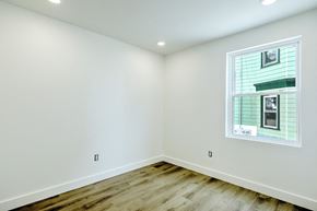 Providence apartment for rent - A room with a window showing a house and trees outside.