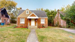 Gary house for rent - A red brick house with a white door and a small porch.