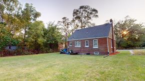 Gary house for rent - A house with a red brick exterior and a green lawn in front.