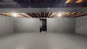 Gary house for rent - A spacious, empty room with a door at the end and lights on the ceiling.