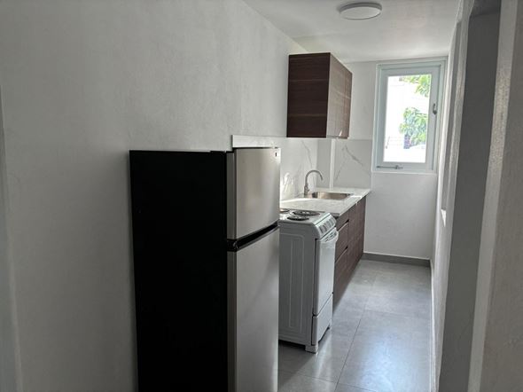 San Juan apartment for rent - A black refrigerator in a kitchen with a white counter.