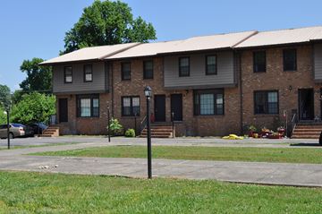 Murfreesboro apartment for rent - A brick building with a metal roof and a car parked in front.
