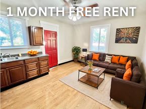 Denver apartment for rent - A red and yellow house with a balcony and stairs leading to the front door.