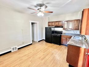 Denver apartment for rent - A wooden bench on a porch with green plants on the wall.