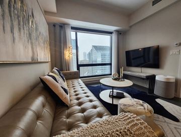 Montréal apartment for rent - A living room with a brown leather sofa and a white coffee table.