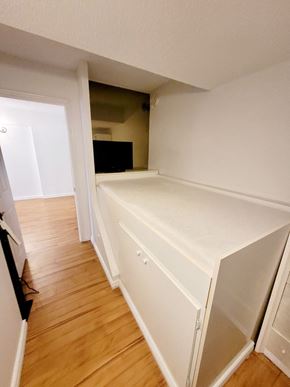 Verdun apartment for rent - A white kitchen with a wooden floor and a white cabinet.