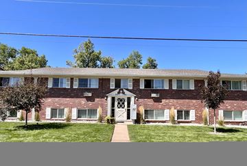 Littleton apartment for rent - A red brick building with a white door and windows.
