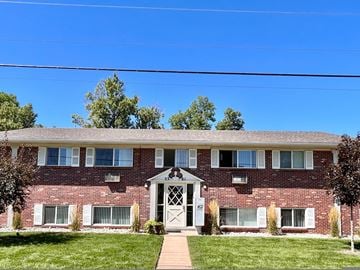 Littleton apartment for rent - A red brick building with a white door and windows.
