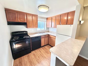 Englewood apartment for rent - A kitchen with black appliances and wooden cabinets.