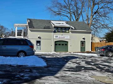 Frederick apartment for rent - A grey van is parked in front of a building with a green door.