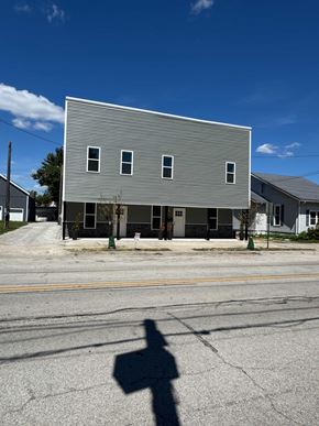 Cridersville apartment for rent - A grey building with a shadow of a person in front of it.