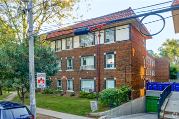 Toronto apartment for rent - A red brick building with a sign that says "Protect Watch".