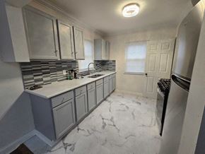Gary house for rent - A kitchen with a marble floor and a stainless steel dishwasher.