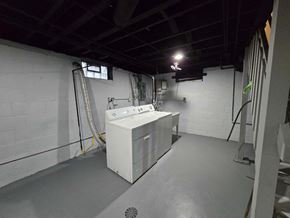 Gary house for rent - A white industrial sink is in a room with a grey floor and walls.