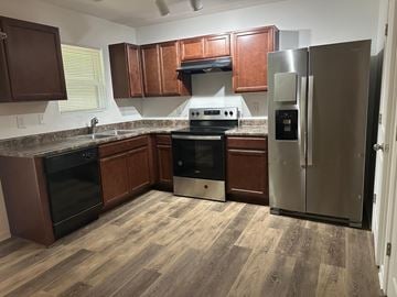 Villa Rica house for rent - A kitchen with wooden cabinets and a stainless steel refrigerator.