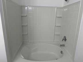 Villa Rica house for rent - A white bathroom with a white tub and white tiles.