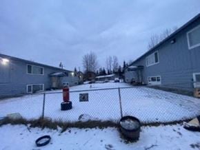 Anchorage apartment for rent - A snow-covered ground with a fence and a red post in the middle.