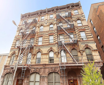 New York apartment for rent - A large, old building with fire escapes on the side.