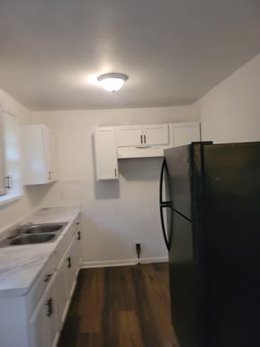 Atlanta house for rent - A black refrigerator in a kitchen with white cabinets.