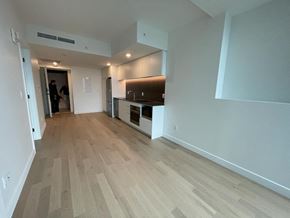 Montréal apartment for rent - A room with wooden flooring and a person standing in the doorway.