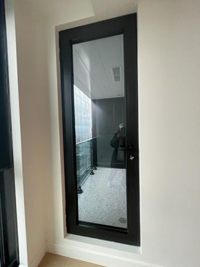 Montréal apartment for rent - A mirror reflects a room with a person standing in it.