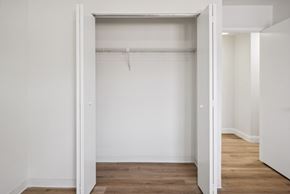 Altoona apartment for rent - A white room with a wooden floor and a white closet with a hanger.
