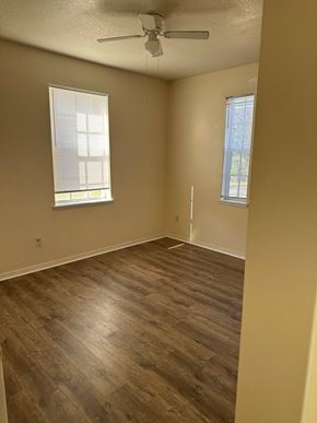 Deltona apartment for rent - A room with a ceiling fan and two windows.