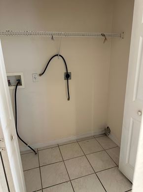 Deltona apartment for rent - A white bathroom with a white door and a white tiled floor.