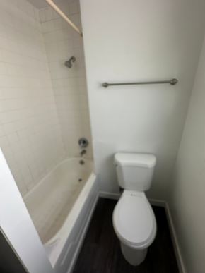 Pasco apartment for rent - A white toilet in a small bathroom with a white tiled shower.