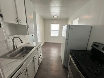 Pasco apartment for rent - A kitchen with white cabinets and a black stove top oven.