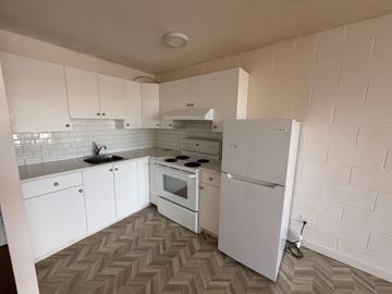 Calgary apartment for rent - A kitchen with white appliances and a white refrigerator.