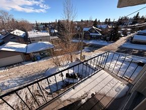 Calgary apartment for rent - A view from a balcony overlooking a snowy residential area.