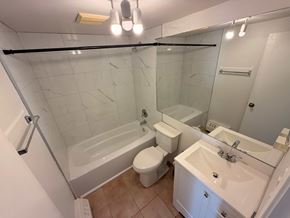 Calgary apartment for rent - A white bathroom with a toilet, sink, and bathtub.