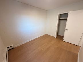 Calgary apartment for rent - A room with a wooden floor and a white door.