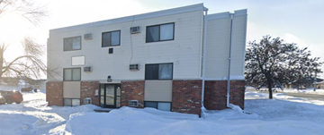 Moorhead apartment for rent - A modern building with a mix of brick and siding exterior is surrounded by snow.