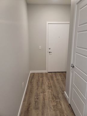 Calgary apartment for rent - A white door is in a room with a wooden floor.