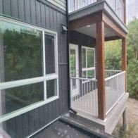 Calgary apartment for rent - A black house with a white railing and a glass door.