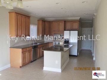 Loudon house for rent - A kitchen with wooden cabinets and a black countertop.