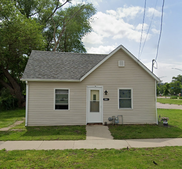 Des Moines house for rent - A small house with a grey roof and a white door.