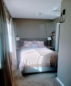 Oakland apartment for rent - A bedroom with a bed, two lamps, and a nightstand.