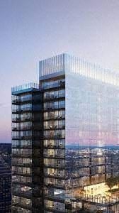 Montreal apartment for rent - A tall glass building stands under a twilight sky.