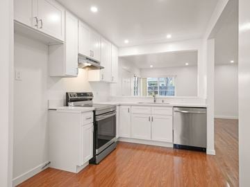 San Leandro apartment for rent - A kitchen with white cabinets and a wooden floor.