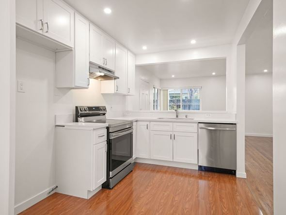 San Leandro apartment for rent - A kitchen with white cabinets and a wooden floor.