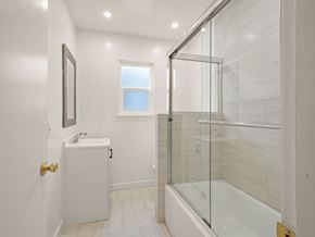 San Leandro apartment for rent - A white bathroom with a glass shower stall and a white sink.